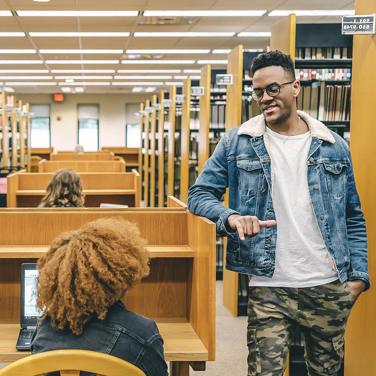  Photo of students chatting together in the library