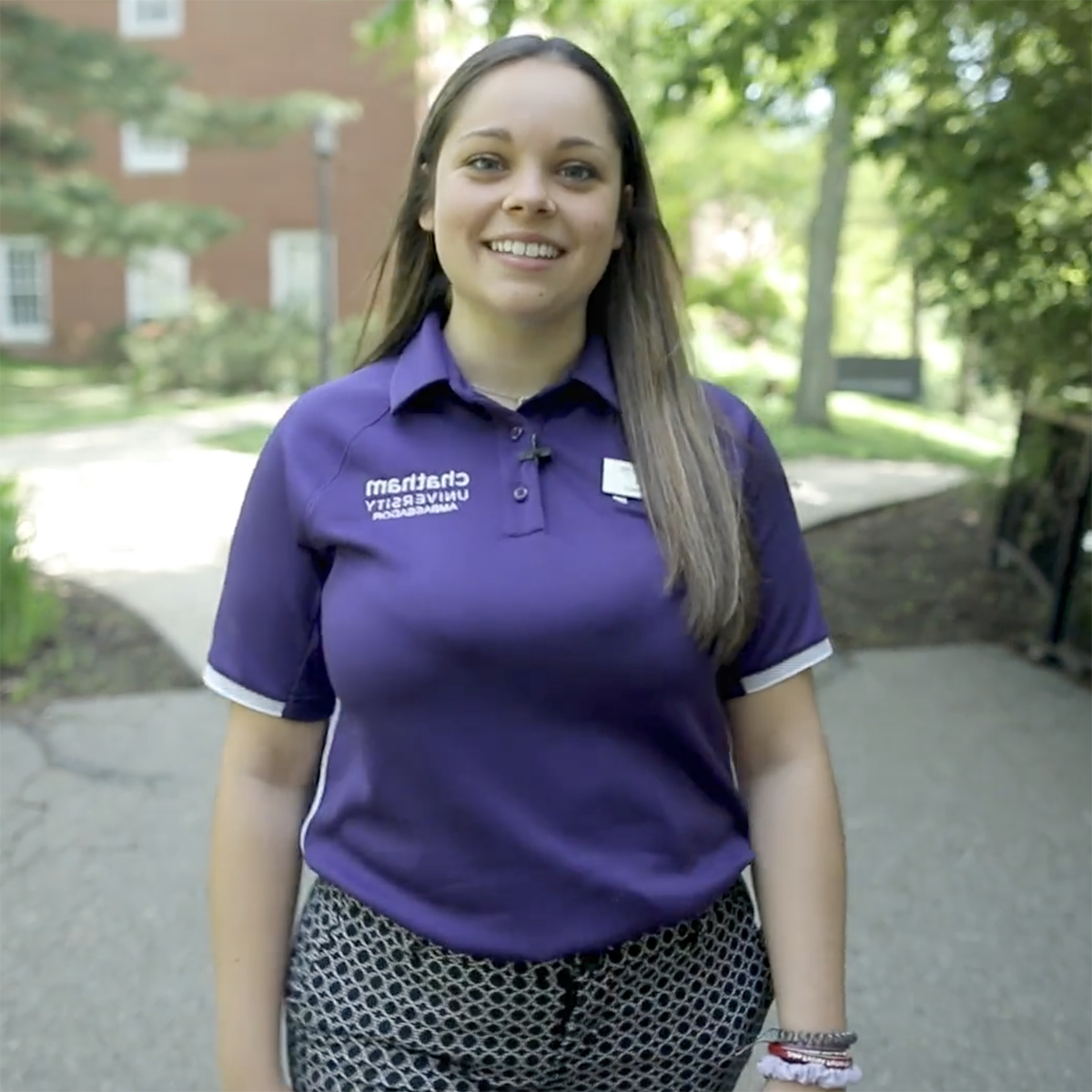 Photo of a Chatham University student in a bright purple polo shirt, smiling